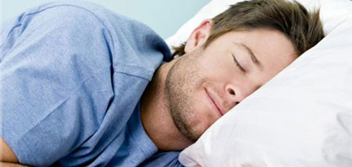 Man fast asleep on bed